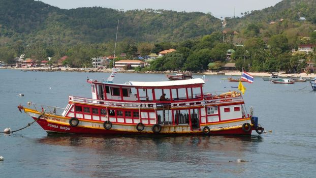 KOH TAO ISLAND, THAILAND - 29 JUNE 2019 Diving boat floating on surface of rippling sea in paradise exotic resort. Sports entertainment for tourists, diving deep under water with equipment