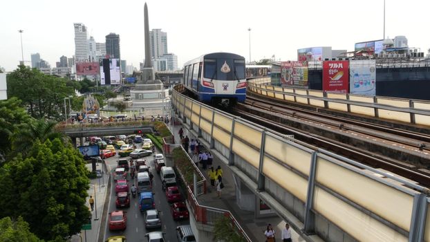 BANGKOK, THAILAND - 10 JULY, 2019: Rush hour traffic near Victory Monumet in Krungthep capital. Famous asian landmark and travel destination. Downtown modern city life. People and passengers of bts