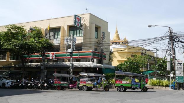 BANGKOK, THAILAND - 11 JULY, 2019: Rush hour traffic near Wat Saket in capital. Famous asian landmark and travel destination. Ancient religious monastery and public transport on the road in downtown