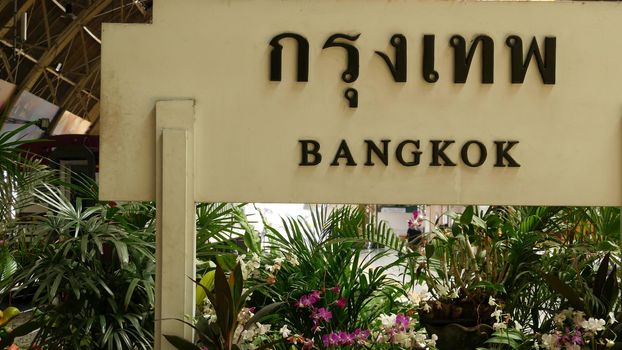 BANGKOK, THAILAND - 11 JULY, 2019: Signpost with name of city. Hua Lamphong main railroad station of state railway transport, SRT. Platform near sign board and trains on tracks