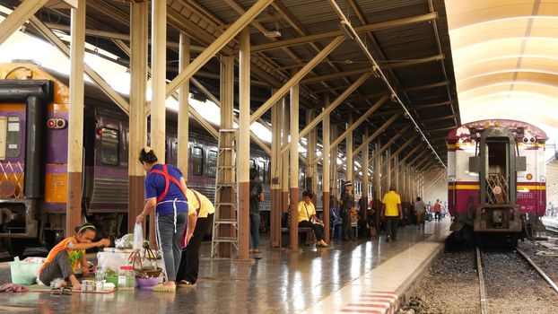 BANGKOK, THAILAND - 11 JULY, 2019: Hua Lamphong railroad station, state railway transport infrastructure SRT. Passengers on platform, people and commuters, trains on tracks. Rail road terminal hub