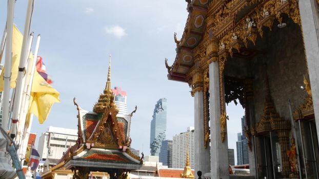 BANGKOK, THAILAND - 13 JULY, 2019: Conceptual contrast of oriental old traditional ancient temple and modern new futuristic Mahanakhon skyscraper. Classic buddhist wat compared to urban cityscape