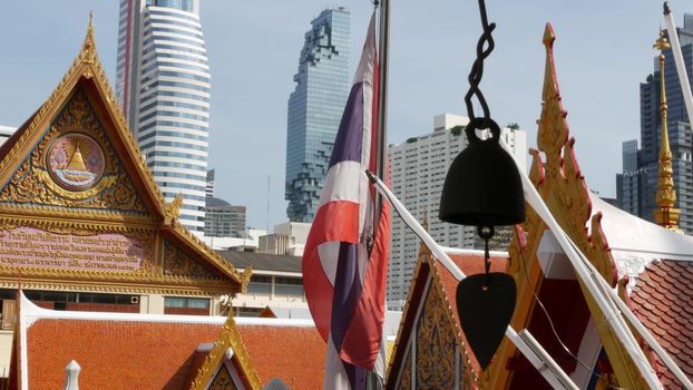 BANGKOK, THAILAND - 13 JULY, 2019: Conceptual contrast of oriental old traditional ancient temple and modern new futuristic Mahanakhon skyscraper. Classic buddhist wat compared to urban cityscape