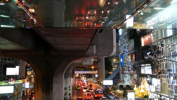 BANGKOK, THAILAND, 13 JULY 2019 Rush hour urban vehicles traffic near MBK, Siam Discovery and Paragon Square reflected upside down in mirror. Downtown modern city life colorful perspective reflection