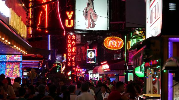 BANGKOK, THAILAND,13 JULY 2019: Vivid neon signs glowing on Soi Cowboy street. Nightlife in erotic Red light district. Illuminated bar and adult go-go show club. Night life tourist entertainment.