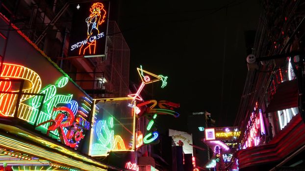 BANGKOK, THAILAND,13 JULY 2019: Vivid neon signs glowing on Soi Cowboy street. Nightlife in erotic Red light district. Illuminated bar and adult go-go show club. Night life tourist entertainment.