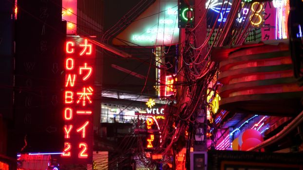 BANGKOK, THAILAND,13 JULY 2019: Vivid neon signs glowing on Soi Cowboy street. Nightlife in erotic Red light district. Illuminated bar and adult go-go show club. Night life tourist entertainment.
