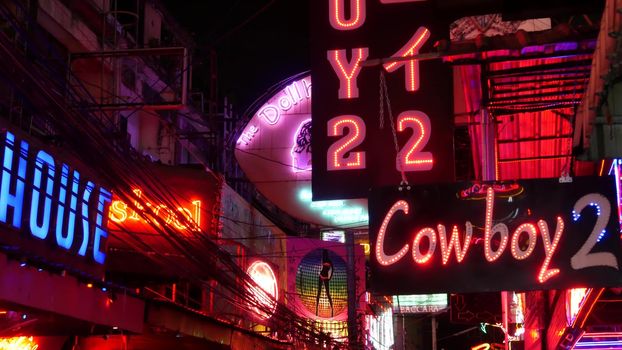 BANGKOK, THAILAND,13 JULY 2019: Vivid neon signs glowing on Soi Cowboy street. Nightlife in erotic Red light district. Illuminated bar and adult go-go show club. Night life tourist entertainment.