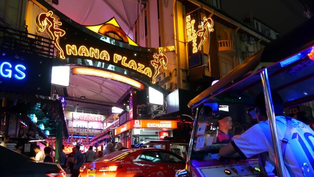 BANGKOK, THAILAND,13 JULY 2019 Vivid neon signs glowing, Nana Plaza street. Nightlife in erotic Red light district soi. Illuminated bar and adult go-go show club. Night life tourist entertainment