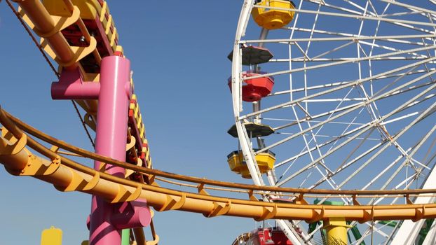 SANTA MONICA, LOS ANGELES, USA - 28 OCT 2019: Iconic colorful retro ferris wheel, roller coaster in amusement park. Famous classic california summertime symbol, pier of pacific ocean beach resort.