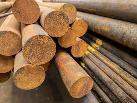 rusted round steel bars pack ends - close-up with selective focus and background blur