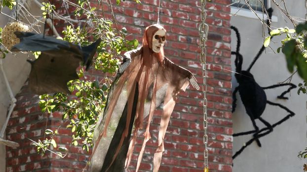 LOS ANGELES, CALIFORNIA, USA - 29 OCT 2019: Scary festival decorations of a house, Happy Halloween holiday. Classic garden with Pumpkin, Bones and Skeleton. Traditional party decor. American culture.