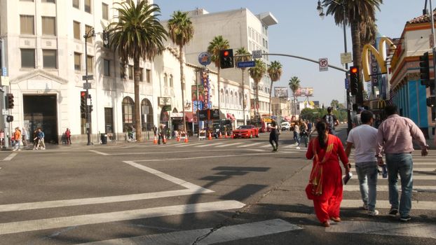 LOS ANGELES, CALIFORNIA, USA - 7 NOV 2019: Walk of fame promenade, Hollywood boulevard in LA city. Pedastrians walking on sidewalk of street. Entertainment and cinema industry iconic tourist landmark.