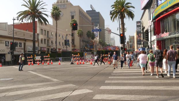 LOS ANGELES, CALIFORNIA, USA - 7 NOV 2019: Walk of fame promenade, Hollywood boulevard in LA city. Pedastrians walking on sidewalk of street. Entertainment and cinema industry iconic tourist landmark.