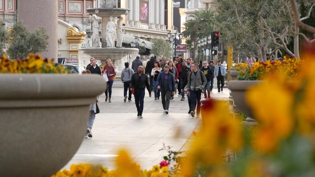 LAS VEGAS, NEVADA USA - 13 DEC 2019: People on pedestrian walkway. Multicultural men and women walking on city promenade. Crowd of citizens on sidewalk. Diversity of multiracial faces in metropolis.