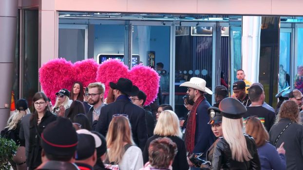 LAS VEGAS, NEVADA USA - 13 DEC 2019: People on pedestrian walkway. Multicultural men and women walking on city promenade. Crowd of citizens on sidewalk. Diversity of multiracial faces in metropolis.