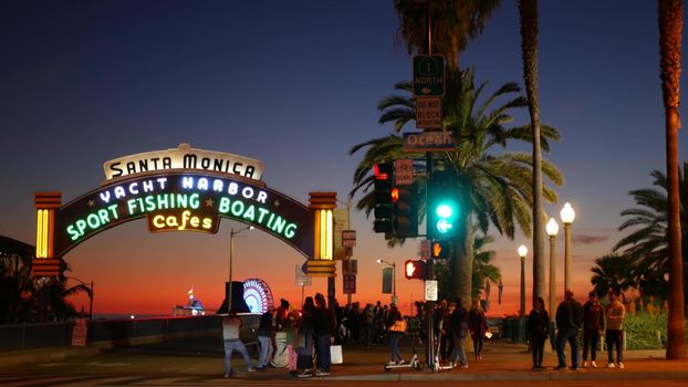 SANTA MONICA, LOS ANGELES CA USA - 19 DEC 2019: Summertime iconic vintage symbol. Classic illuminated retro sign on pier. California summertime aesthetic. Glowing lettering on old-fashioned signboard.