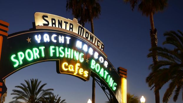 SANTA MONICA, LOS ANGELES CA USA - 19 DEC 2019: Summertime iconic vintage symbol. Classic illuminated retro sign on pier. California summertime aesthetic. Glowing lettering on old-fashioned signboard.