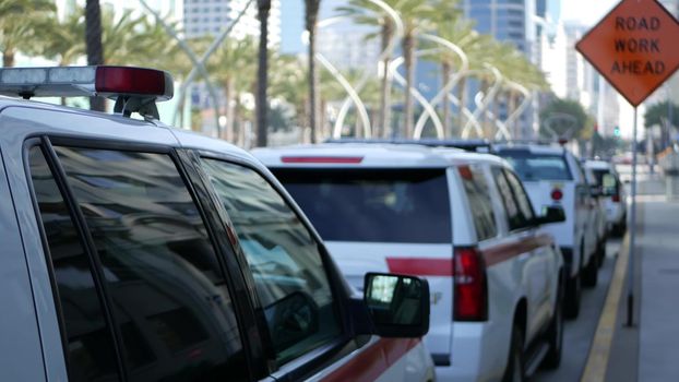 SAN DIEGO, CALIFORNIA USA - 15 JAN 2020: Fire department trucks and Sheriff's car with emergency sirens parked on Broadway. Firefighters vehicles in downtown. Fire engine for rescue and public safety.