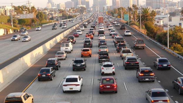 SAN DIEGO, CALIFORNIA USA - 15 JAN 2020: Busy intercity freeway, traffic jam on highway during rush hour. Urban skyline and highrise skyscrapers. Transportation concept and transport in metropolis.