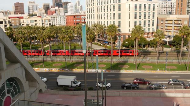 SAN DIEGO, CALIFORNIA USA - 30 JAN 2020: MTS red trolley and metropolis urban skyline, highrise skyscrapers in city downtown. From above aerial view, various buildings in Gaslamp Quarter and tram.