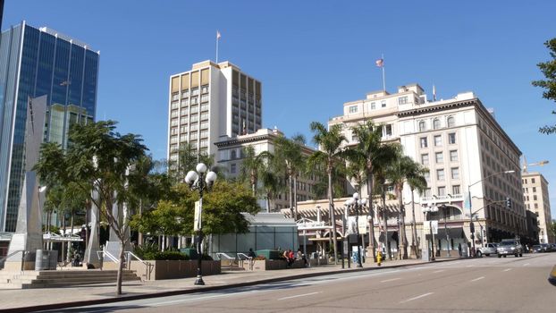 SAN DIEGO, CALIFORNIA USA - 13 FEB 2020: Pedestrians, traffic and highrise buildings in city downtown. Street life of american metropolis. Urban street, transport and citizens walking on walkways.