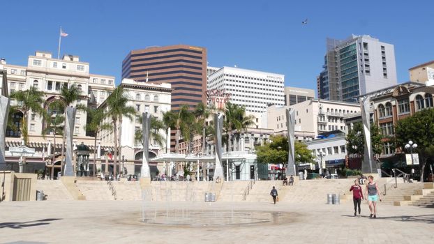 SAN DIEGO, CALIFORNIA USA - 13 FEB 2020: Metropolis urban downtown. Fountain in Horton Plaza Park, various highrise buildings and people in Gaslamp Quarter. Citizens walking in financial district.
