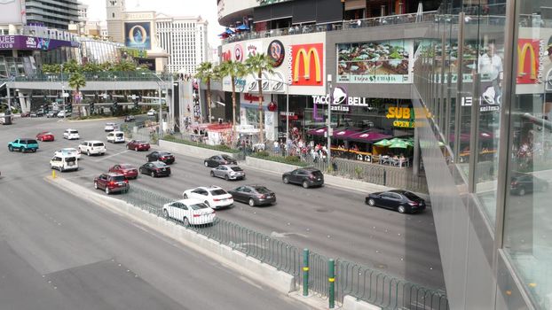 LAS VEGAS, NEVADA USA - 7 MAR 2020: The Strip boulevard with luxury casino and hotels in gambling sin city. Car traffic on road to Fremont street in tourist money playing resort. People and McDonalds.