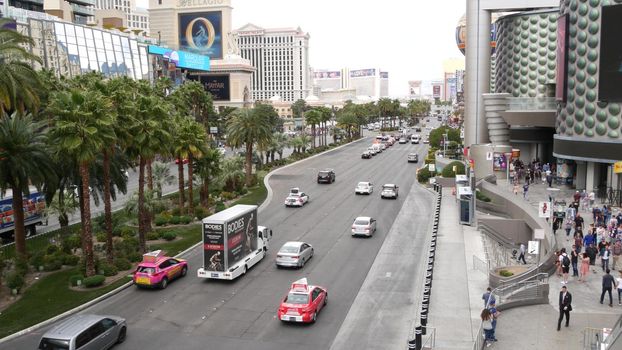 LAS VEGAS, NEVADA USA - 7 MAR 2020: The Strip boulevard with luxury casino and hotels in gambling sin city. Car traffic on road to Fremont street in tourist money playing resort. People walking.