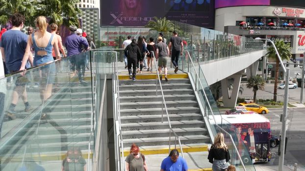 LAS VEGAS, NEVADA USA - 7 MAR 2020: People on pedestrian walkway. Multicultural men and women walking on city promenade. Crowd of citizens on sidewalk. Diversity of multiracial faces in metropolis.