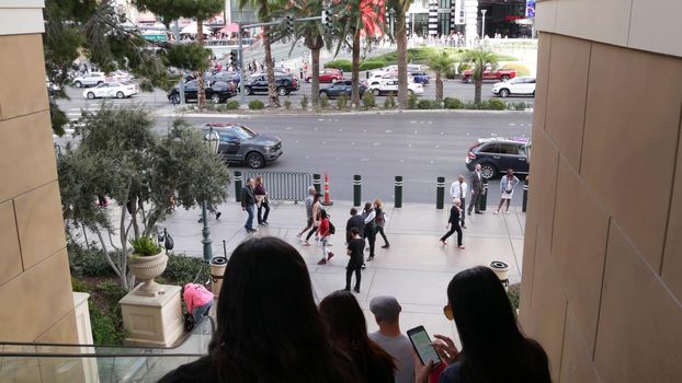 LAS VEGAS, NEVADA USA - 7 MAR 2020: People on pedestrian walkway. Multicultural men and women walking on city promenade. Crowd of citizens on sidewalk. Diversity of multiracial faces in metropolis.