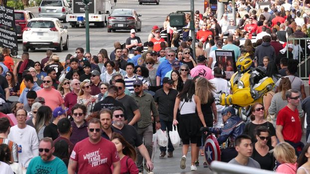 LAS VEGAS, NEVADA USA - 7 MAR 2020: People on pedestrian walkway. Multicultural men and women walking on city promenade. Crowd of citizens on sidewalk. Diversity of multiracial faces in metropolis.