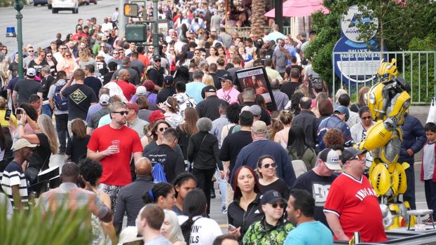 LAS VEGAS, NEVADA USA - 7 MAR 2020: People on pedestrian walkway. Multicultural men and women walking on city promenade. Crowd of citizens on sidewalk. Diversity of multiracial faces in metropolis.