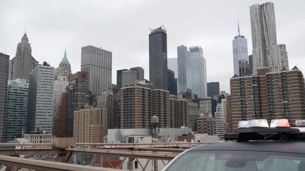 NEW YORK CITY, USA - 12 MAR 2020: Emergency siren glowing, 991 police patrol car on Brooklyn bridge. NYPD auto, symbol of crime prevention and safety in Manhattan. Metropolis security and protection.