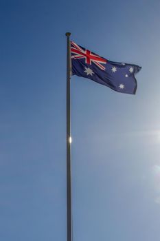 Australian flag slowly waving on the beautiful blue sky in Australia