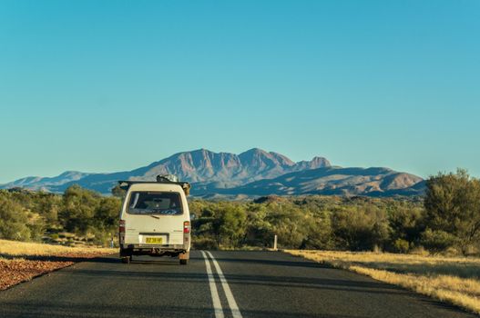 Scenic panorama of a car driving on the namatjira drive to MacDonnell National Park in NT central outback Australia.