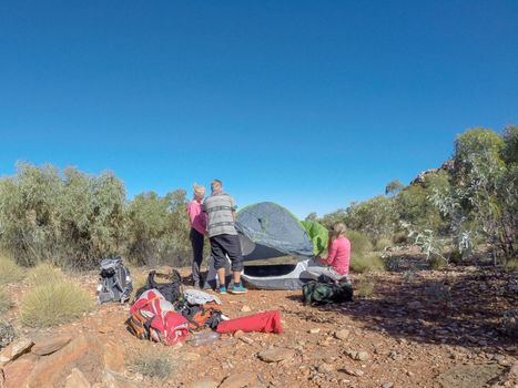 group of hikers putting up a tent in the dessert