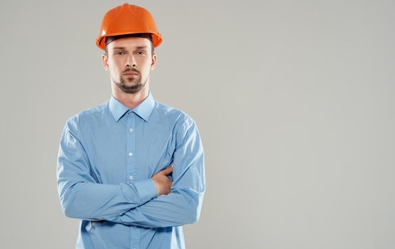 male architect in an orange helmet crossed his arms on his chest Copy Space. High quality photo