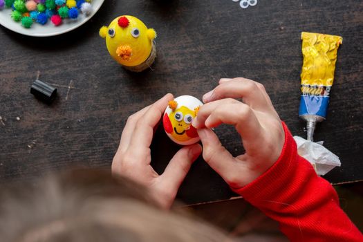 Girl making figurines from eggs, top view