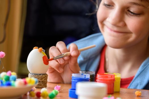 Happy girl painting easter eggs for the holiday