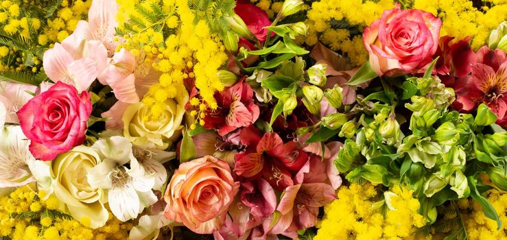 Flowers border composition in bright yellow red colours. Alstroemeria, roses, mimosa flowers. Flat lay top view, copy space