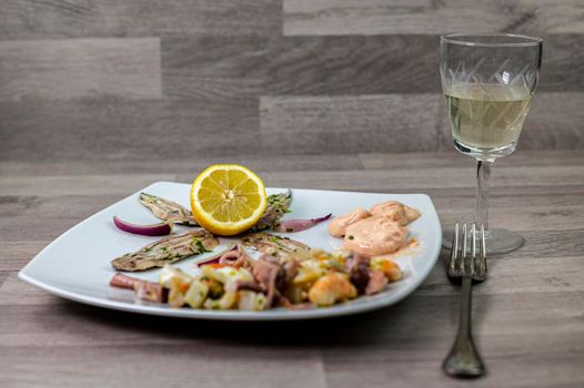 appetizer with seafood goblet of wine and cutlery on wooden background