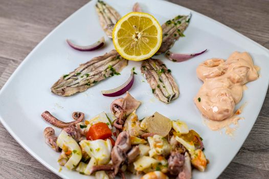 appetizer with seafood goblet of wine and cutlery on wooden background
