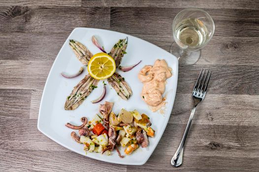 appetizer with seafood goblet of wine and cutlery on wooden background