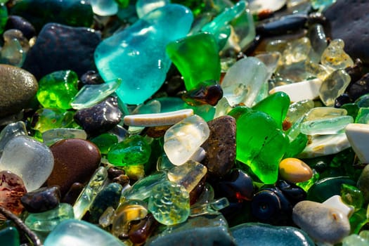 Natural background with sea glass close-up on sand. Vladivostok, Glass beach.