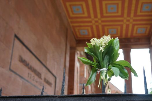 Kaliningrad, Russia. Bouquet of lilies of the valley on the metal fence of Kant's
