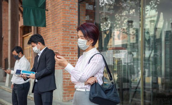 Asian middle aged people wearing mask and keep social distancing to avoid the spread of COVID-19