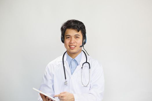 Young asian doctor with stethoscope talking with patient on white background