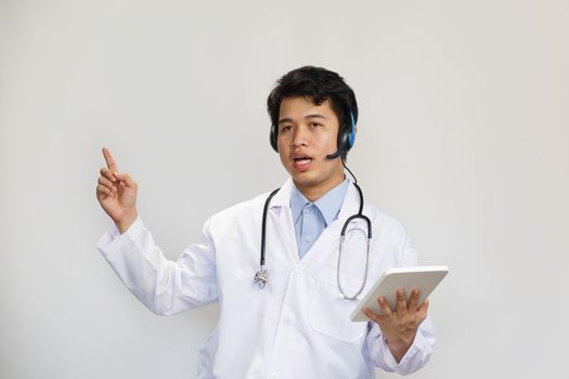 Young asian doctor with stethoscope talking with patient on white background