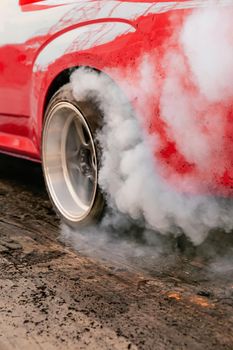 Drag racing car burns rubber off its tires in preparation for the race